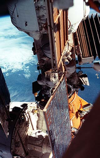 Views of the Space Shuttle Atlantis as it docks to the Mir Space Station. The crew compartment nose and portions of the payload bay are visible behind a Mir Space Station solar array.